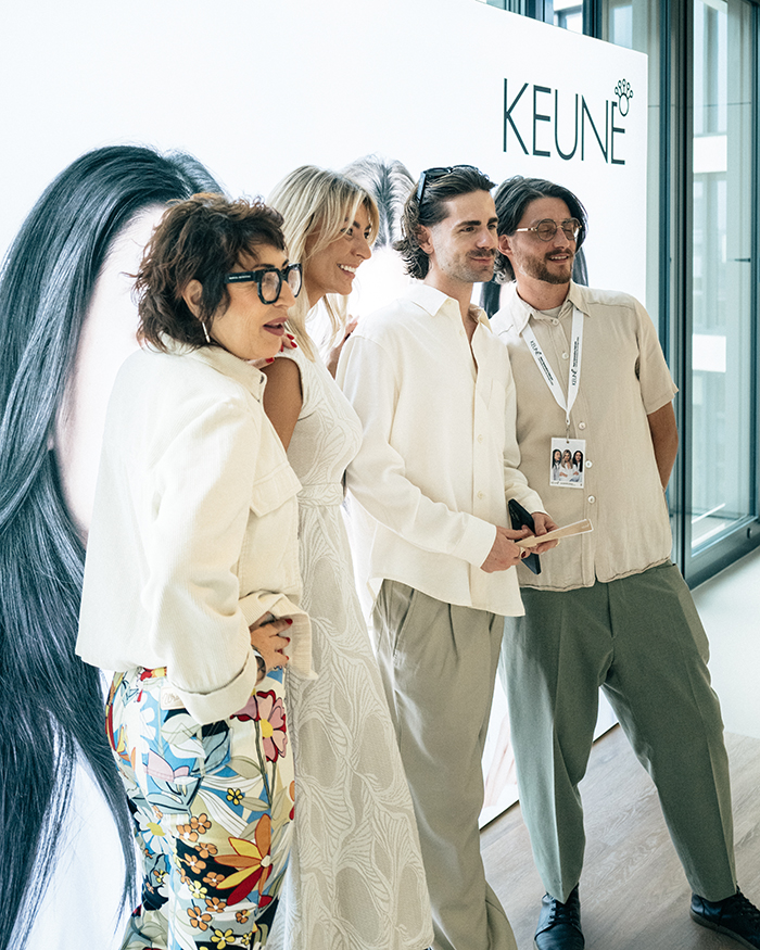 Gruppenbild vor einer beleuchteten Werbewand des KEUNE Care-Serie Relaunch in Frankfurt