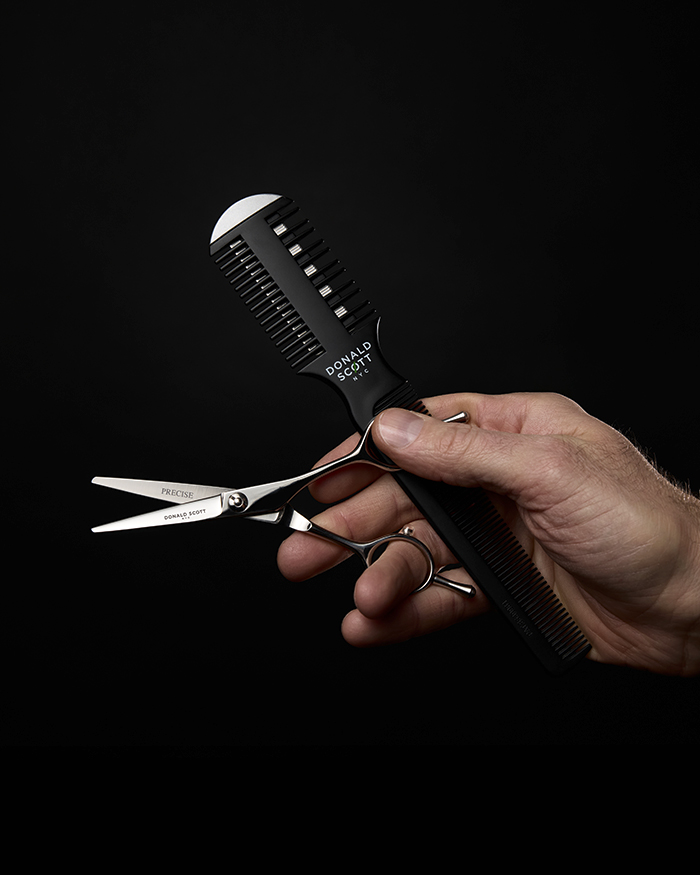 Hand mit Schere und Kamm