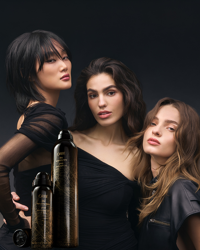 Kampagnen Bild dreier Models mit toll texturiertem Haar & den Produkten von Oribe Dry Texturizing Spray