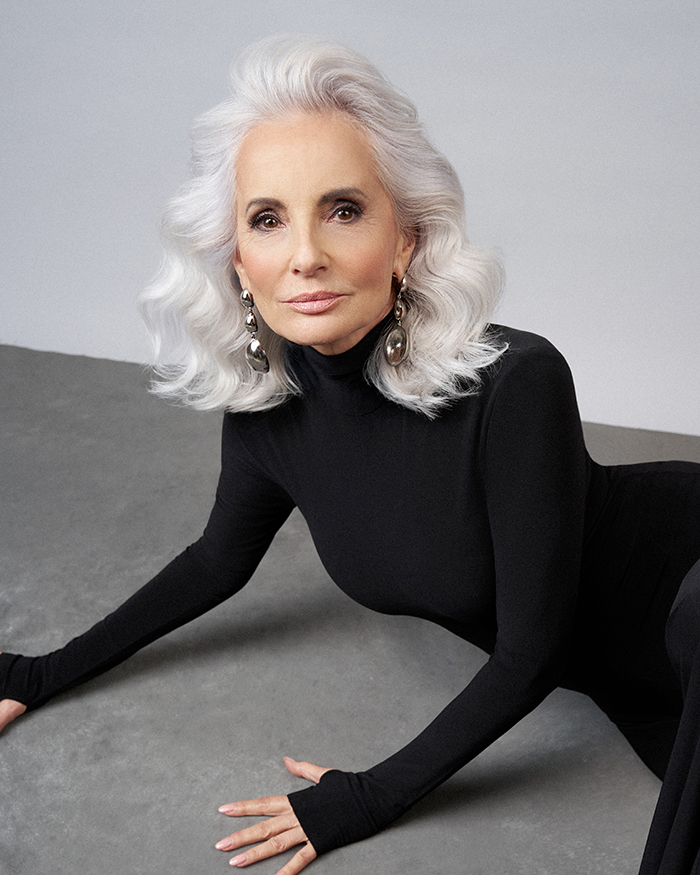 Älteres Model im schwarzen Kleid mit perfekt gestyltem grauem Haar – inspiriert von der SILVER.sense Pflege für graues Haar.