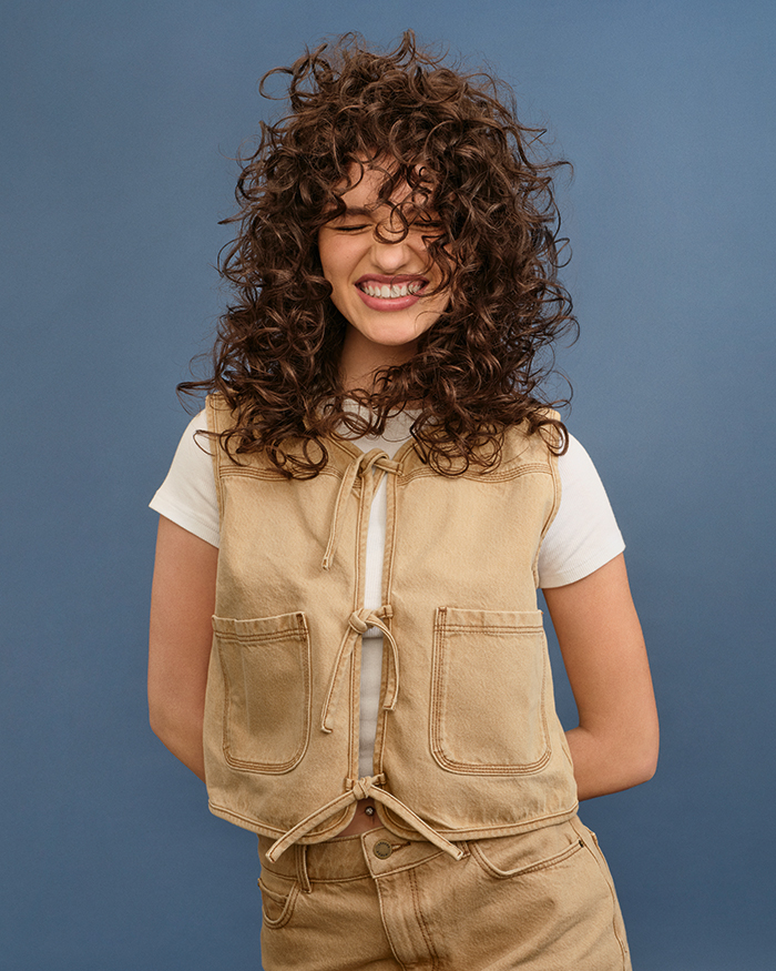 Lachendes Model vor blauem Hintergrund mit perfekter Pflege für trockenes Haar von Schwarzkopf