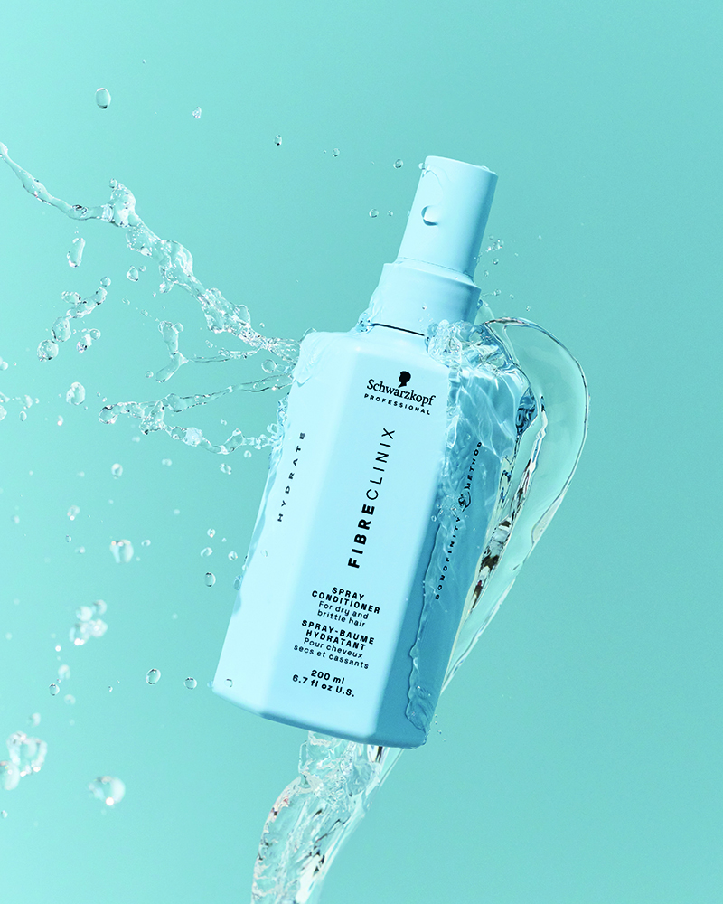 Schwarzkopf Fibre Clinix Spray Conditioner hellblaue Flasche, Haarpflege-Spray für Sommerhaarpflege, Feuchtigkeit und Schutz vor Sonnenschäden, auf hellblauem Hintergrund mit Wasser