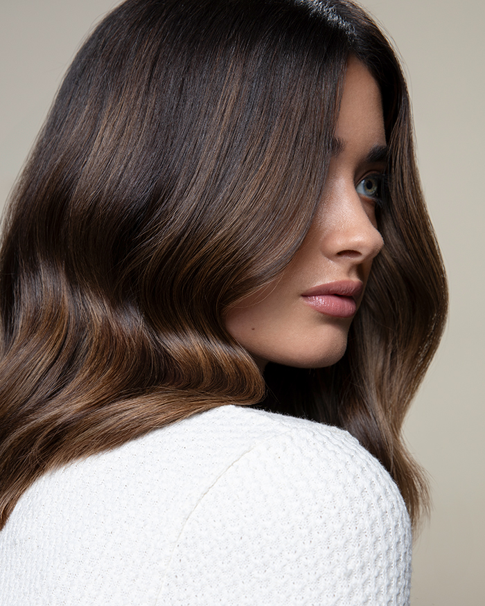 Seitliche Nahaufnahme eines Models mit Schokoladenbraunem Haar gefärbt mit den The Demi Chocolates Nuancen von Paul Mitchell